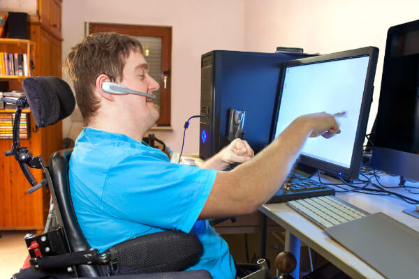Young man with developmental disability working at a computer workstation.
