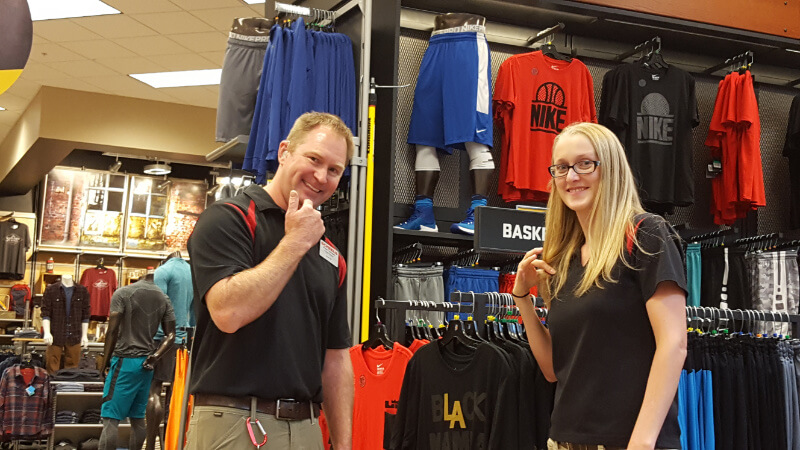 A young couple who are both deaf working together at Scheels and using ASL.