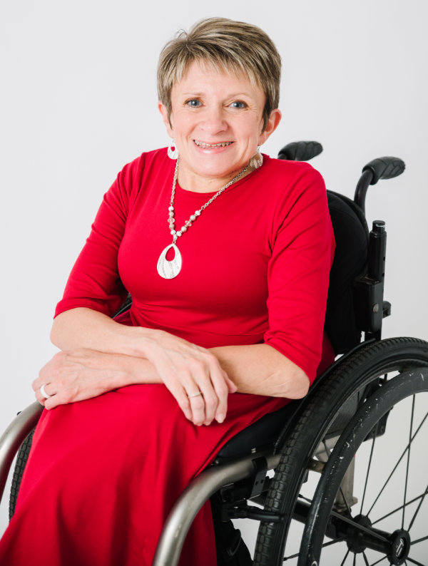 Vicki Stewart smiling and sitting in a wheelchair.